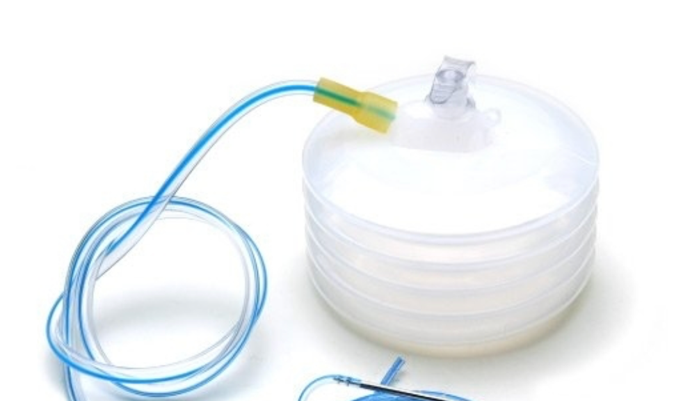 Imagem mostrando um dreno Portovac, muito utilizado na cirurgia plástica. Ele é composto por um dispositivo parecido com uma sanfona e um tubo alongado que realiza a retirada de líquidos